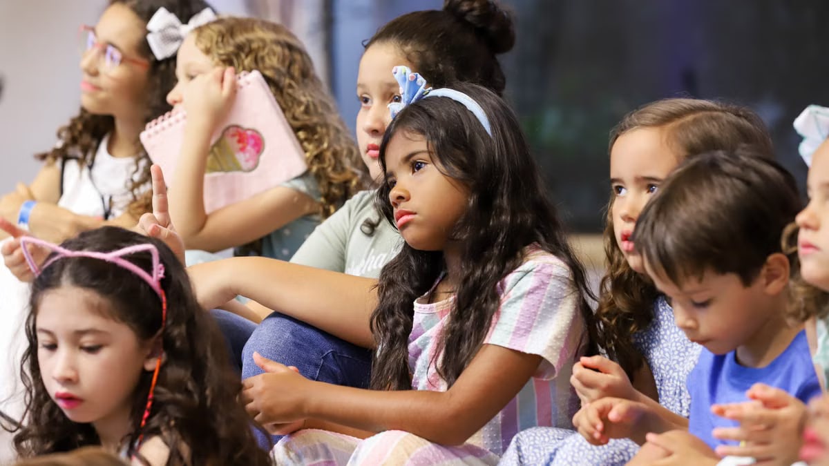 Children attentively sitting in a classroom, engaged in learning activities.